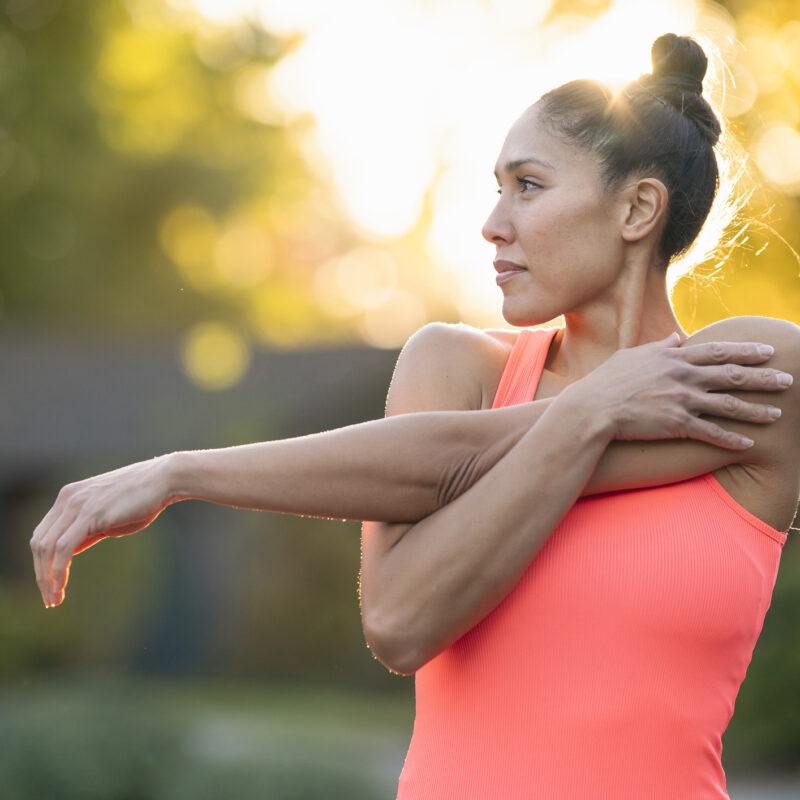 Beautiful female athlete stretching before outdoor workout | Yonifit
