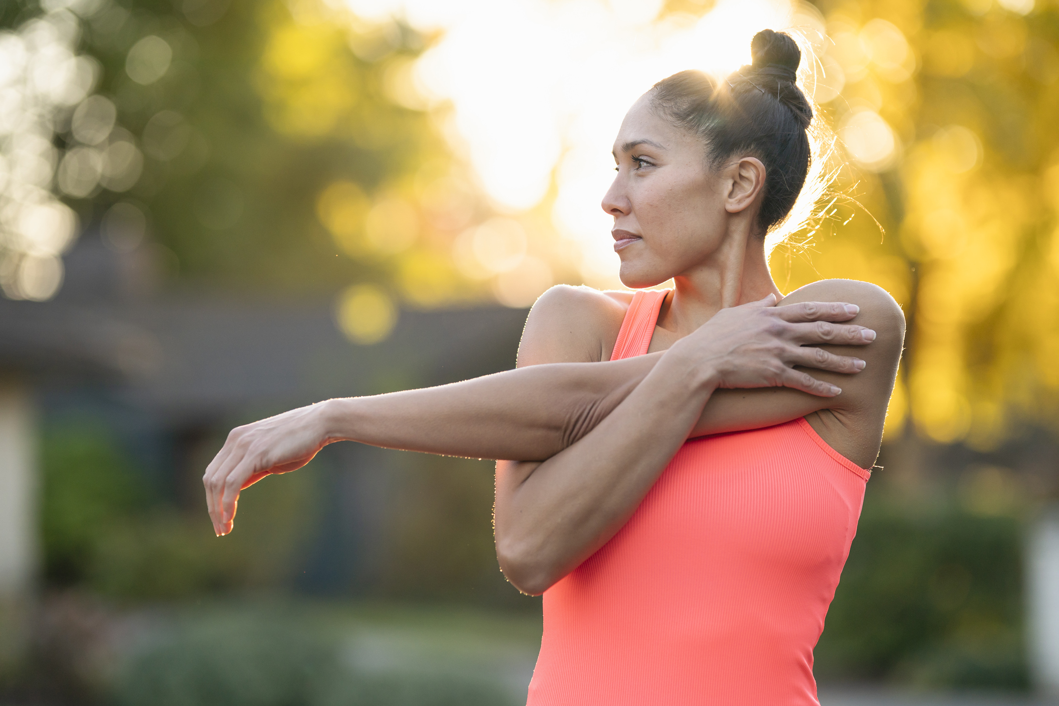 Beautiful female athlete stretching before outdoor workout | Yonifit